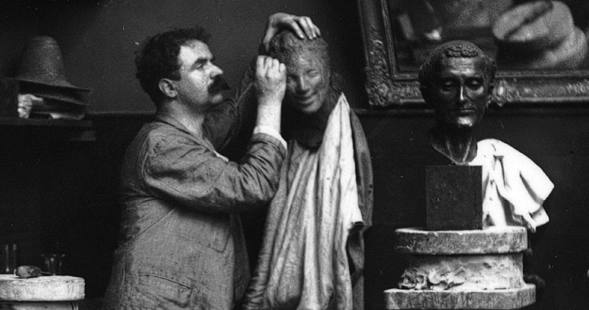 Paris 1890, self-portrait in the studio. From left, Medardo Rosso working on the head of Rieuse in raw clay, bronze copy of Donatello’s St. Francis and second variant of Gavroche decentred on a wooden base. Modern contact print from original negative on glass, 13 x 17.7 cm.